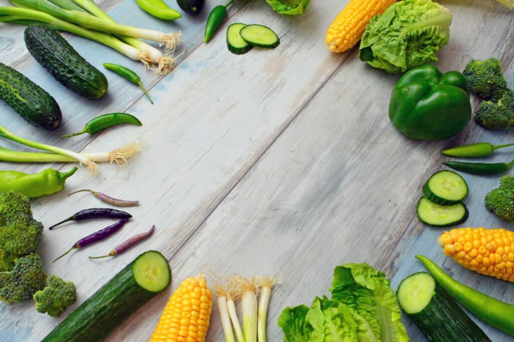 An assortment of fresh vegetables on a wooden table, perfect for healthy cooking.