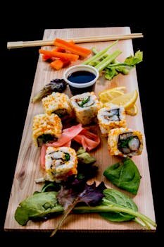 Vibrant sushi platter with fresh vegetables and soy sauce on a wooden board.