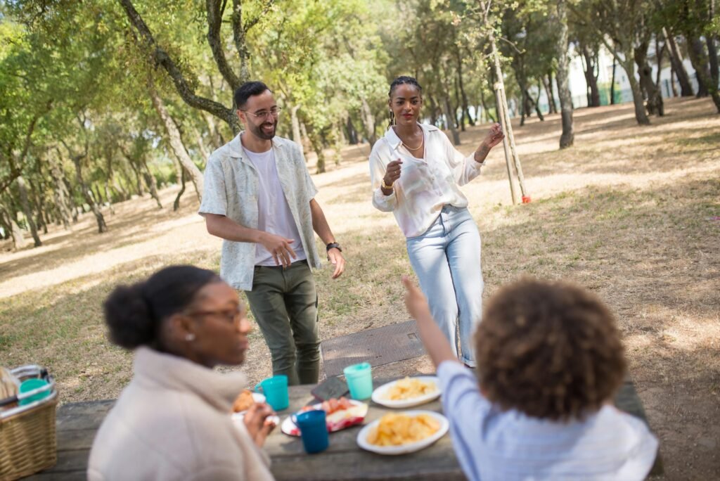 Group enjoying a lively picnic in a Portuguese park, with food and dance.
